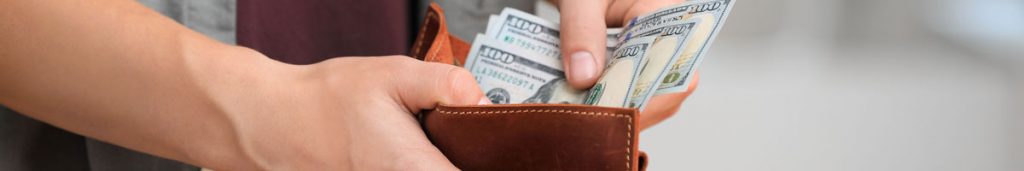 Cash payment being concealed in a wallet, representing financial secrecy and hidden infidelity