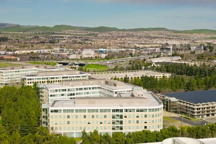 Aerial view of office campus, highway and rolling hills in Alameda County, California