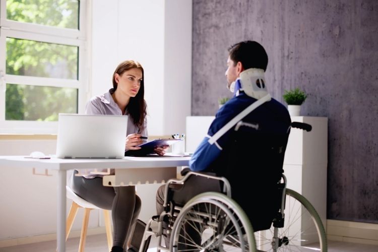 Investigator interviewing injured client in wheelchair with neck brace for injury surveillance evaluation