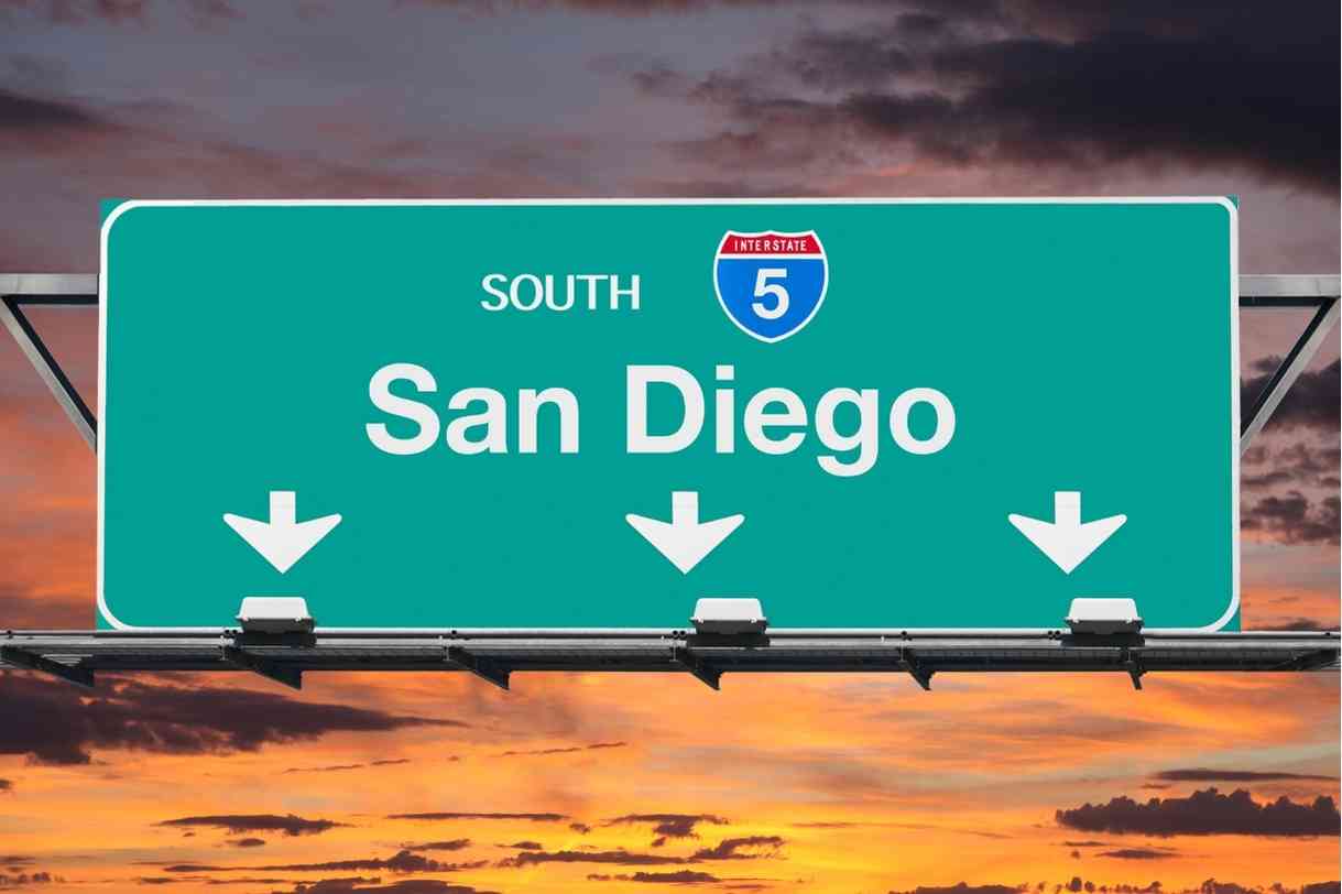Interstate 5 freeway sign reading “San Diego” against a sunset — San Diego private investigator