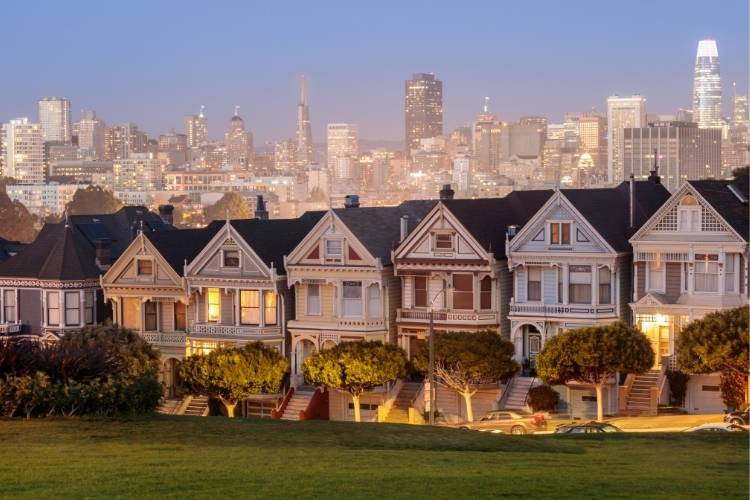 Victorian Painted Ladies at Alamo Square with San Francisco skyline at dusk