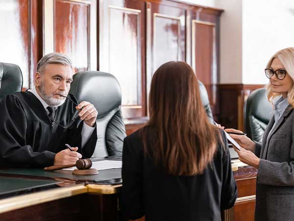 Judge and attorneys conferring at courtroom bench during bankruptcy and foreclosure fraud hearing