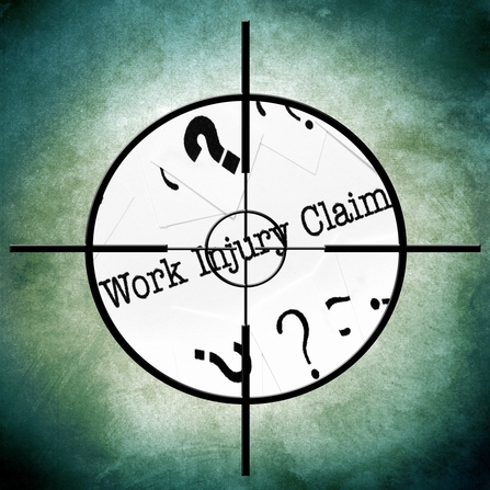 Crosshairs centered on paper reading 'Work Injury Claim' with question marks — insurance surveillance investigating claim
