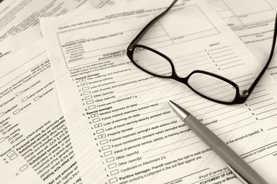 Subpoena service paperwork with reading glasses and pen, illustrating difficult subpoena service challenges