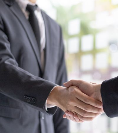 Two professionals shaking hands representing Tristar's commitment and trust for private investigator services in Anaheim