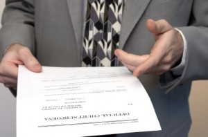 Person in suit presenting court paperwork, illustrating difficult process serving and legal investigation support
