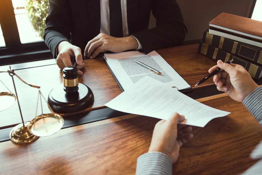 Attorney reviewing legal documents during a discussion about multiple failed service attempts and litigation strategy.